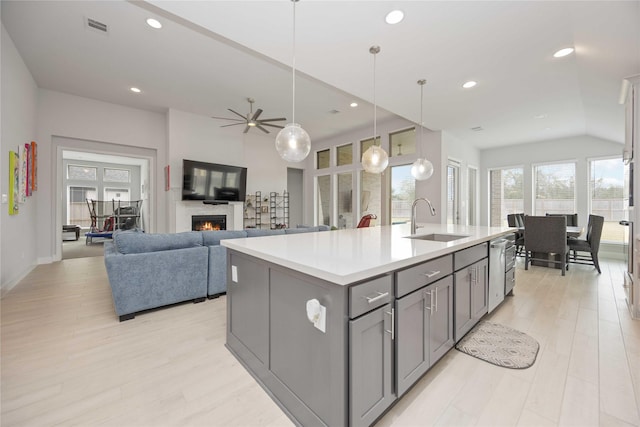 kitchen with ceiling fan, gray cabinetry, a kitchen island with sink, pendant lighting, and sink