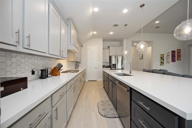 kitchen featuring decorative backsplash, sink, hanging light fixtures, and appliances with stainless steel finishes