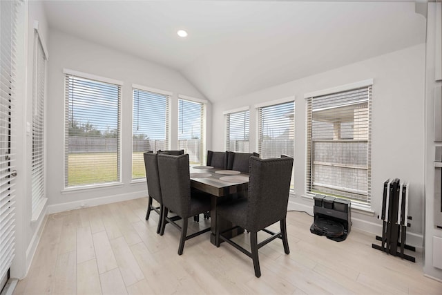 dining room featuring vaulted ceiling and light hardwood / wood-style floors