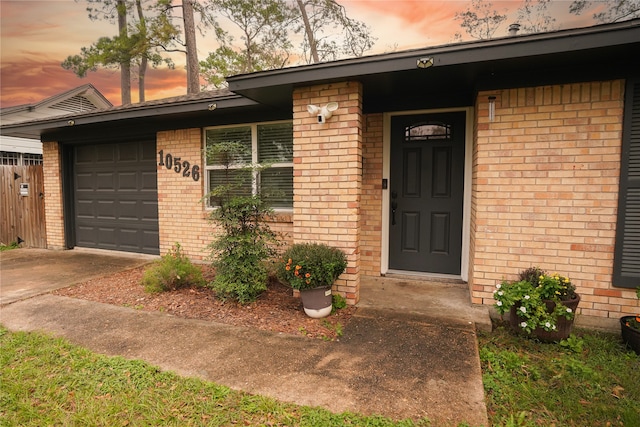 exterior entry at dusk featuring a garage