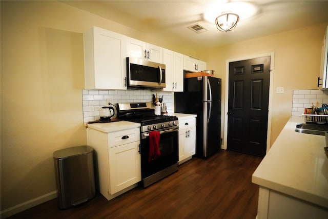 kitchen featuring stainless steel appliances, dark wood-type flooring, sink, white cabinetry, and backsplash