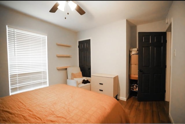 bedroom with dark hardwood / wood-style flooring and ceiling fan