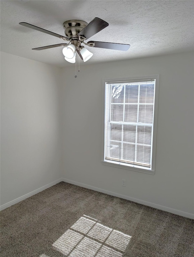 empty room featuring carpet, ceiling fan, and a textured ceiling