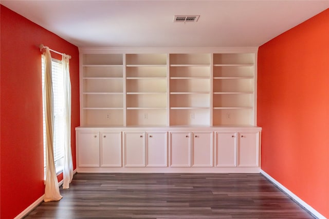 spare room featuring dark hardwood / wood-style flooring and built in features