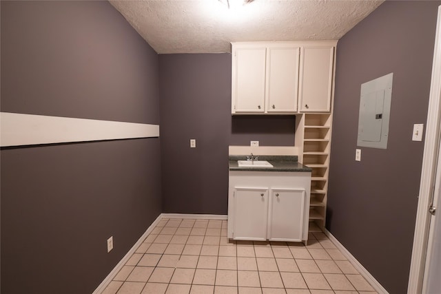 kitchen featuring electric panel, white cabinets, sink, a textured ceiling, and light tile patterned flooring