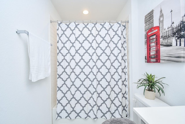 bathroom featuring shower / bath combo with shower curtain and vanity