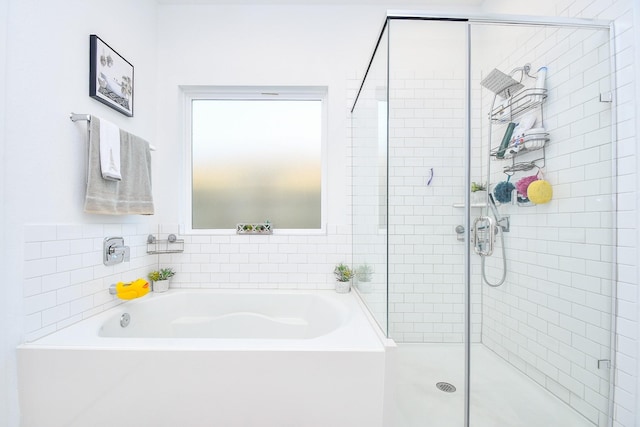 bathroom featuring shower with separate bathtub