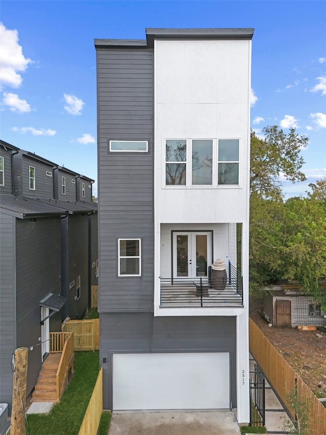 rear view of house featuring french doors and a garage