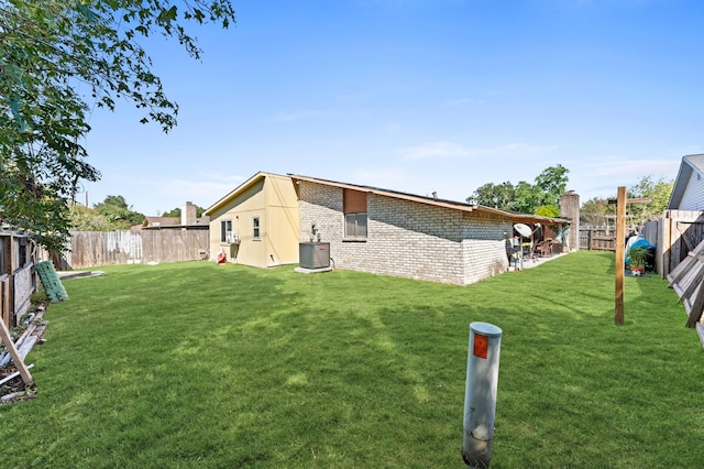 back of house featuring a yard and cooling unit