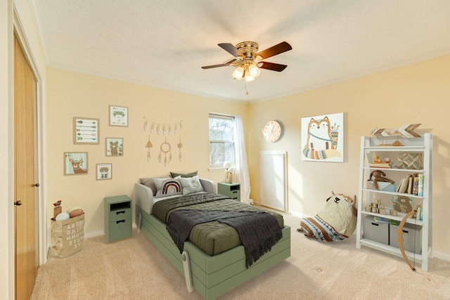 bedroom with ceiling fan, a closet, light carpet, and ornamental molding