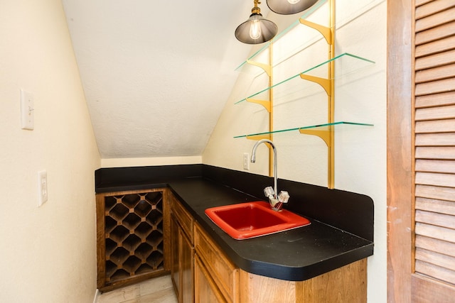 bar featuring light tile patterned flooring, sink, and vaulted ceiling