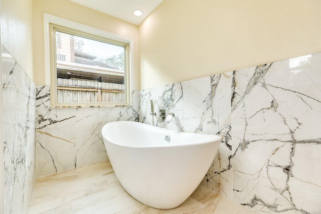 bathroom featuring a bathing tub and tile walls