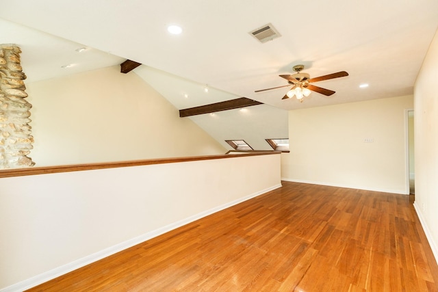 spare room with vaulted ceiling with beams, ceiling fan, and wood-type flooring