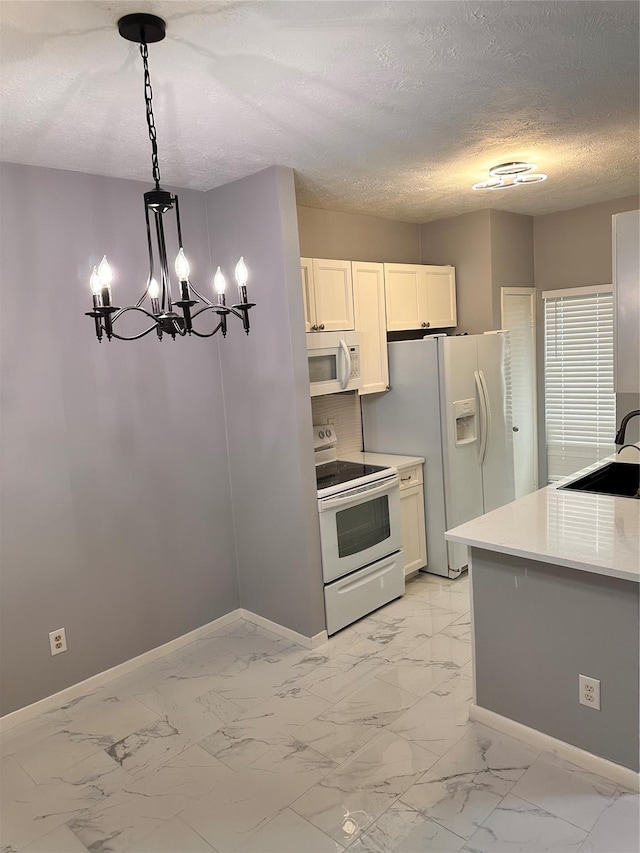 kitchen featuring white appliances, an inviting chandelier, white cabinets, sink, and hanging light fixtures