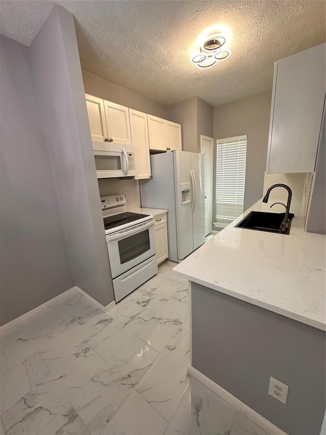 kitchen featuring light stone countertops, a textured ceiling, white appliances, sink, and white cabinets