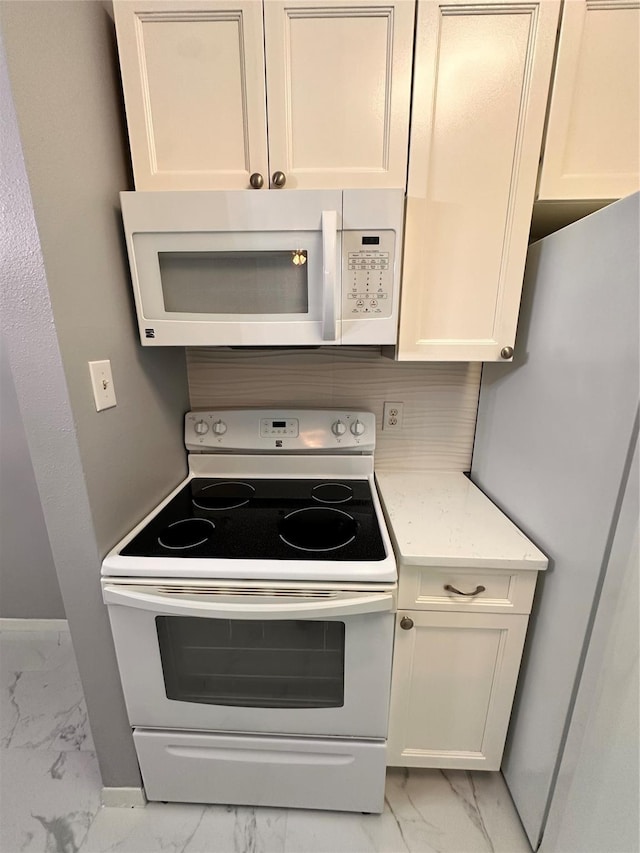 kitchen with white appliances and white cabinetry