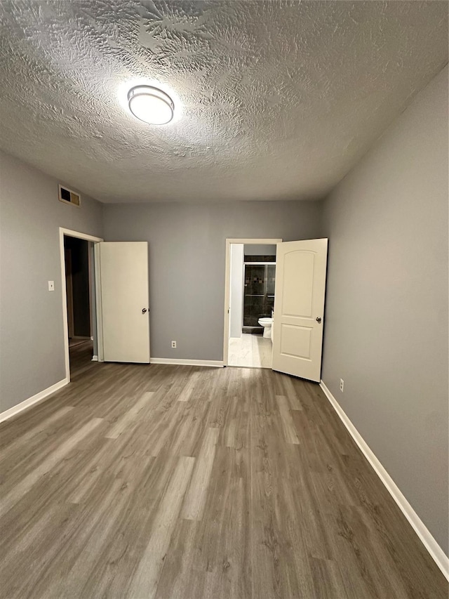 unfurnished bedroom featuring hardwood / wood-style floors and a textured ceiling