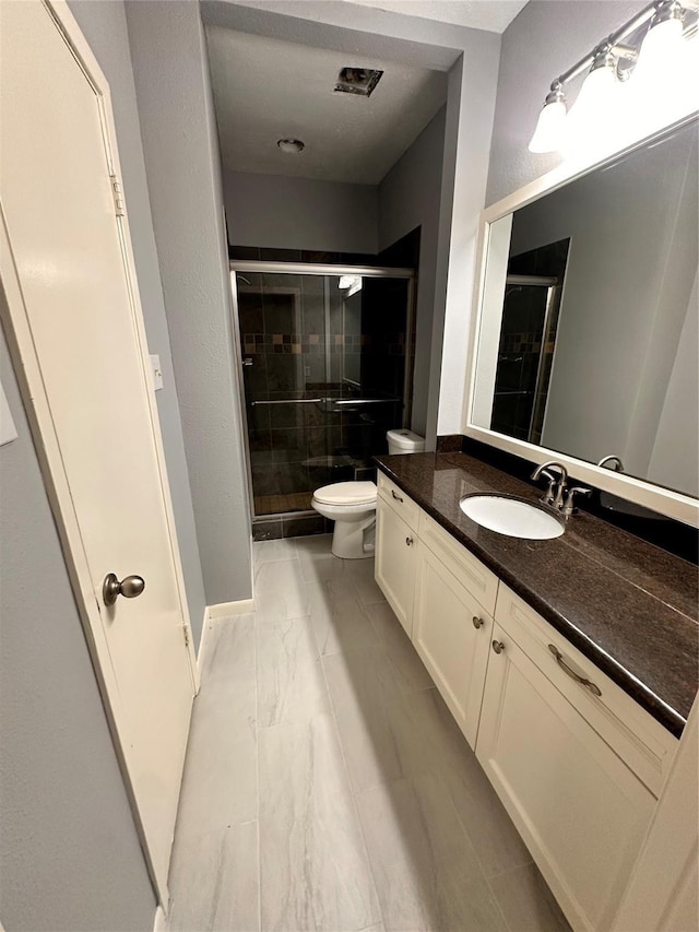 bathroom with vanity, toilet, and walk in shower