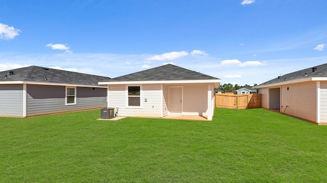 rear view of house featuring central air condition unit and a lawn