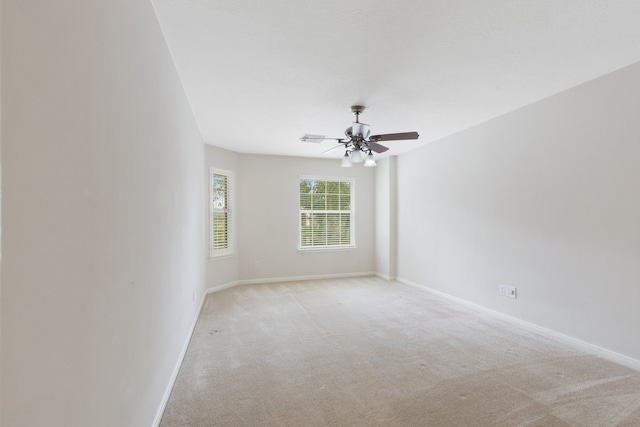 carpeted spare room with ceiling fan