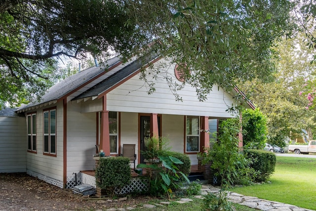 bungalow-style home featuring a porch and a front yard