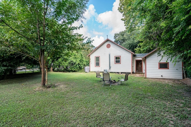 rear view of property featuring a lawn