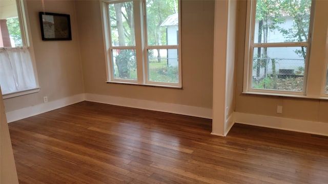 empty room featuring dark hardwood / wood-style floors and plenty of natural light