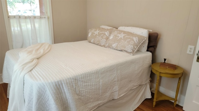 bedroom with dark hardwood / wood-style flooring