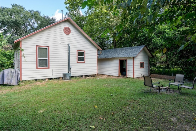 rear view of property with an outbuilding and a yard