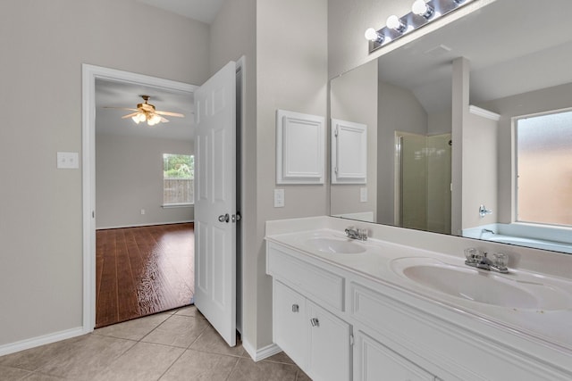 bathroom with tile patterned flooring, ceiling fan, walk in shower, and vanity