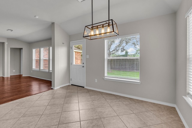 tiled entrance foyer featuring lofted ceiling and a notable chandelier