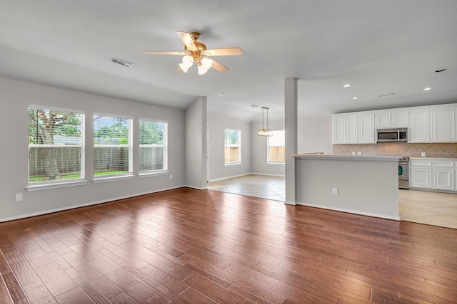 unfurnished living room with hardwood / wood-style flooring, ceiling fan, and lofted ceiling