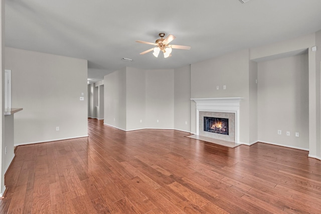 unfurnished living room with hardwood / wood-style flooring, ceiling fan, and a fireplace