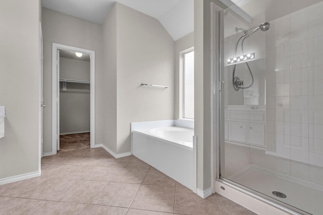 bathroom with tile patterned flooring, shower with separate bathtub, and vaulted ceiling