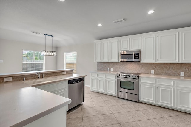 kitchen with sink, white cabinets, decorative light fixtures, and appliances with stainless steel finishes