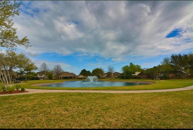 surrounding community featuring a lawn and a water view