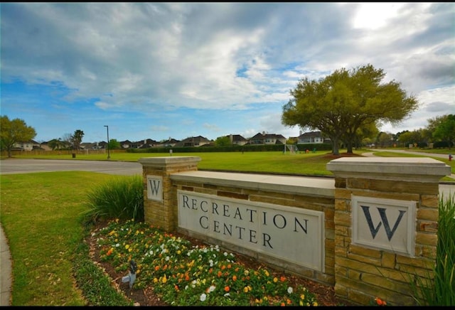 community / neighborhood sign featuring a lawn