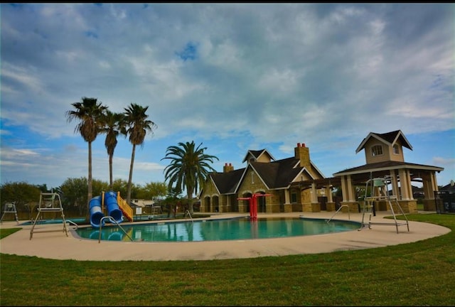 view of pool featuring a patio area, a yard, and a water slide