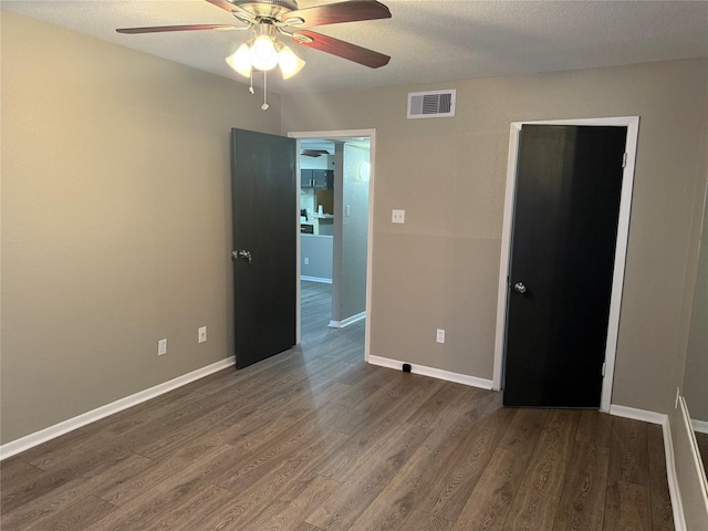 spare room featuring a textured ceiling, dark hardwood / wood-style flooring, and ceiling fan