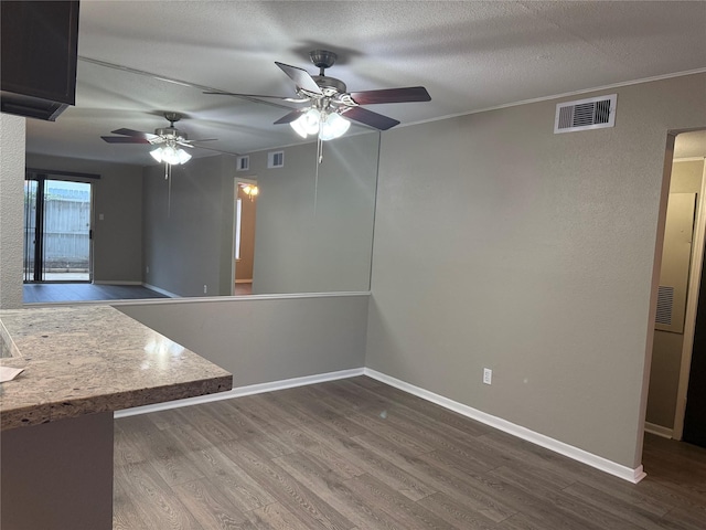 unfurnished room with hardwood / wood-style flooring, ceiling fan, and a textured ceiling