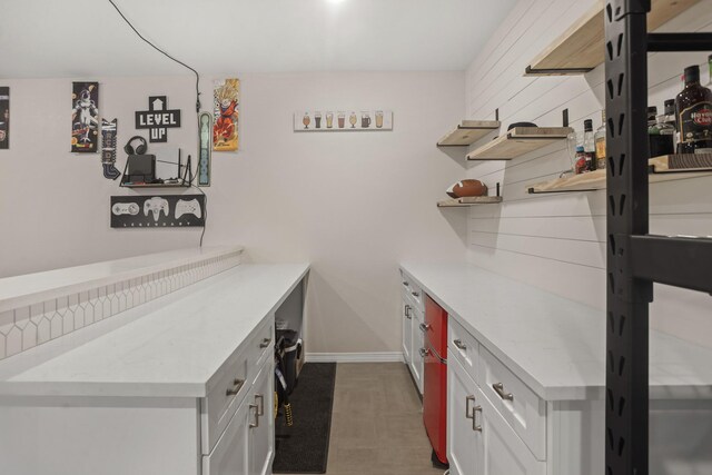 bar featuring white cabinets and light stone countertops