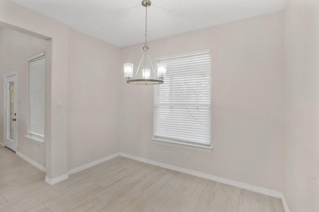 unfurnished room featuring a notable chandelier