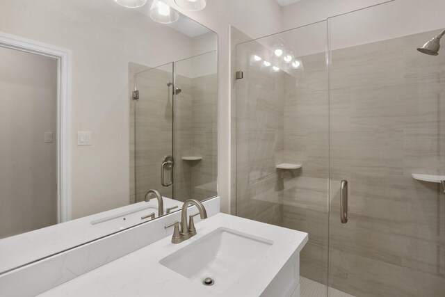 bathroom with vanity and a shower with shower door