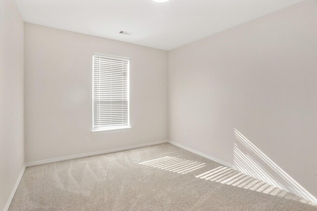 unfurnished room featuring a healthy amount of sunlight and light carpet