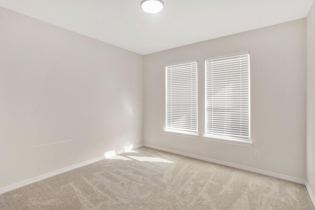 unfurnished room featuring light carpet