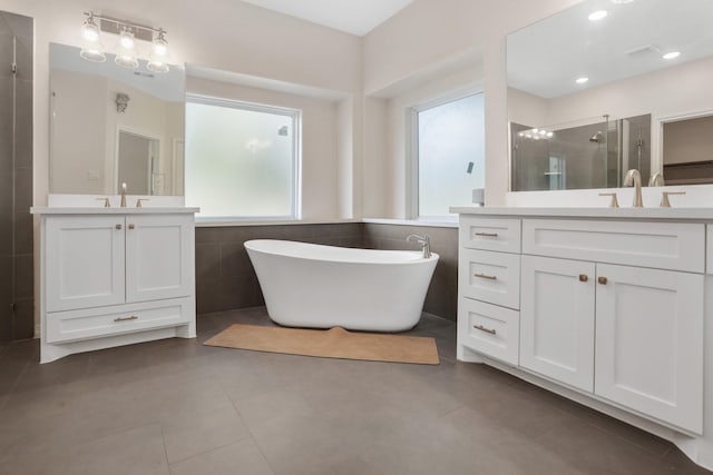 bathroom with tile patterned flooring, shower with separate bathtub, and vanity