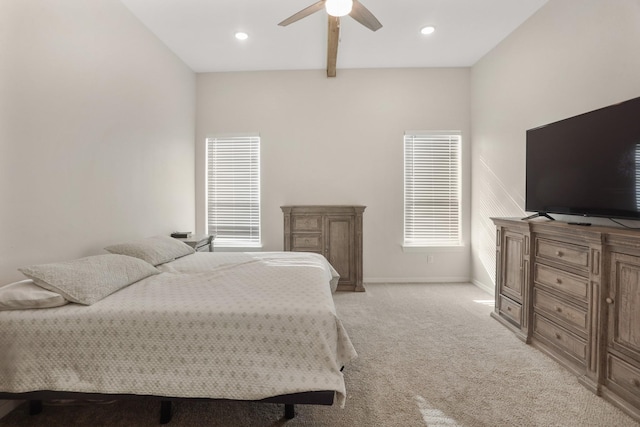 carpeted bedroom with multiple windows, ceiling fan, and beamed ceiling