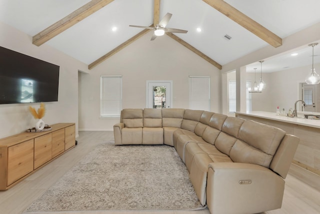 living room with beamed ceiling, ceiling fan with notable chandelier, light hardwood / wood-style floors, and high vaulted ceiling