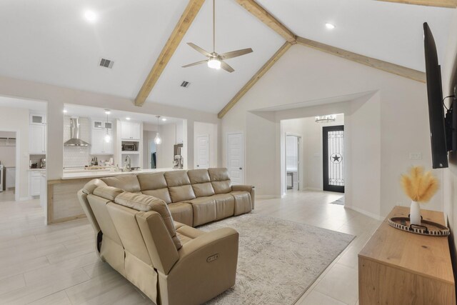 living room featuring beam ceiling, high vaulted ceiling, ceiling fan, and sink