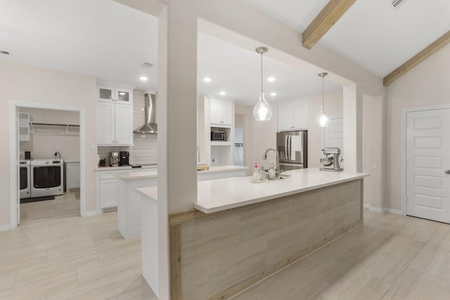 kitchen featuring stainless steel refrigerator with ice dispenser, white cabinets, wall chimney exhaust hood, a center island with sink, and beamed ceiling